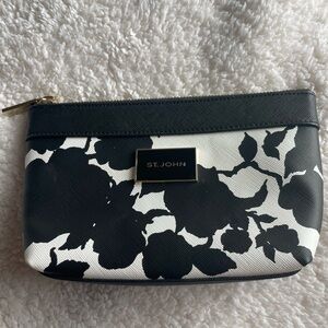 ST.JOHN black and white cosmetic bag with gold toned zipper and ST. JOHN emblem.